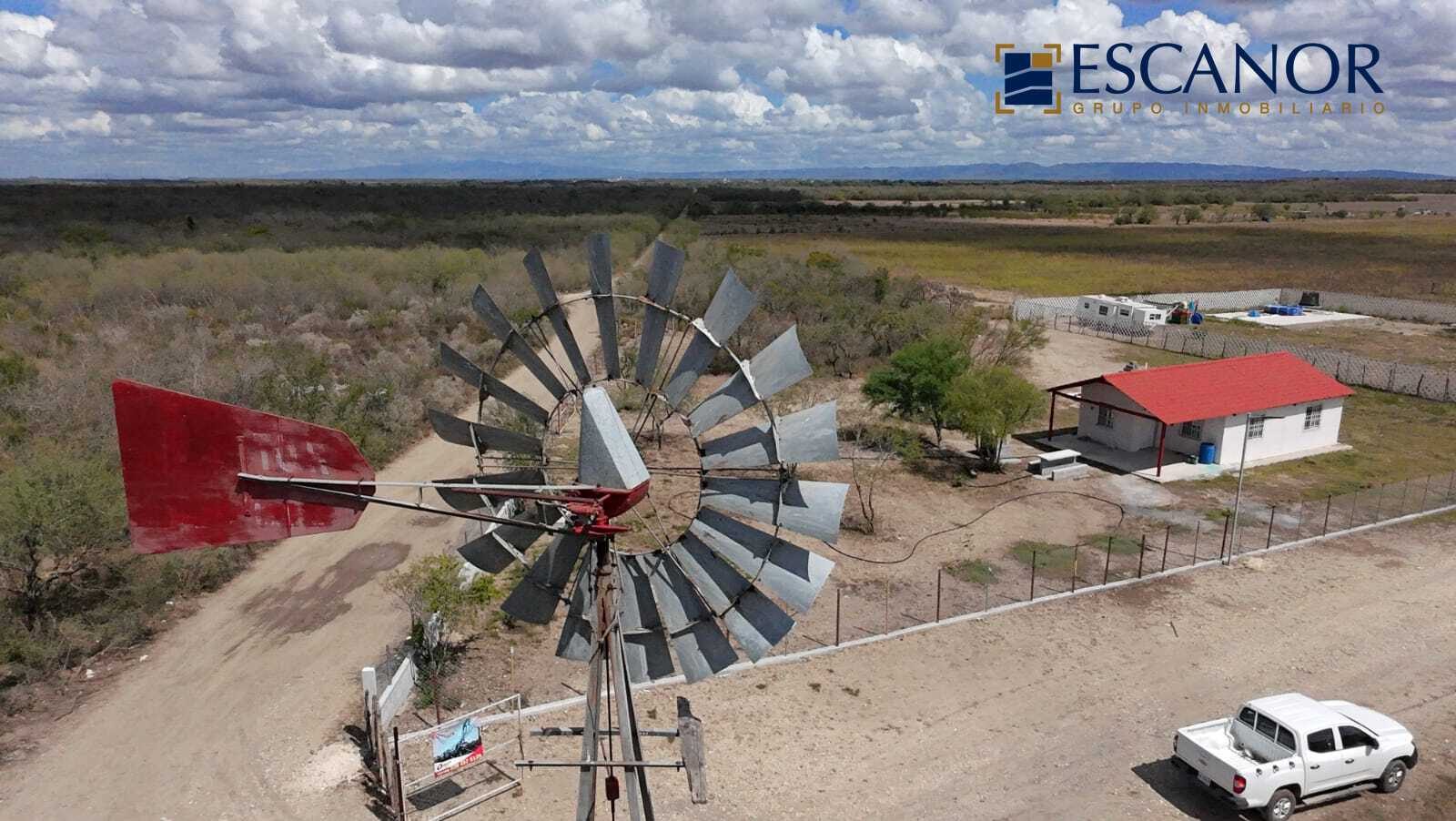 Vista aérea de terreno con casa campestre, molino y camino de acceso